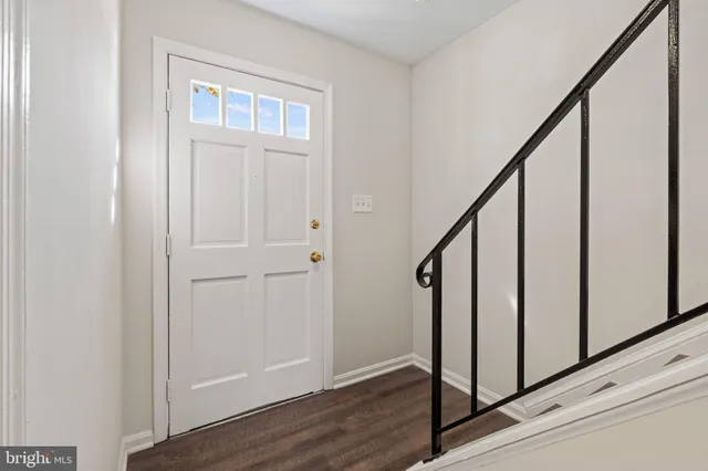 a view of staircase with railing and white walls
