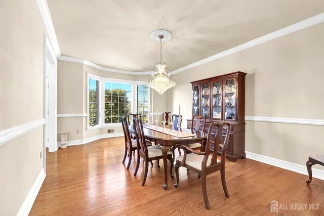 a dining room with furniture window and wooden floor
