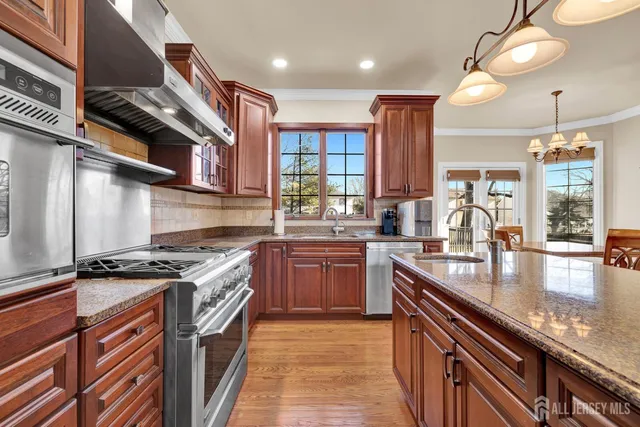 a kitchen with stainless steel appliances granite countertop a stove a sink and a microwave
