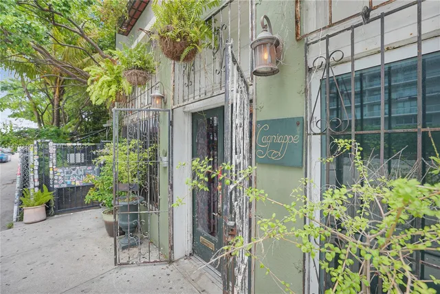 a vase of flowers sitting on a floor in front of a house