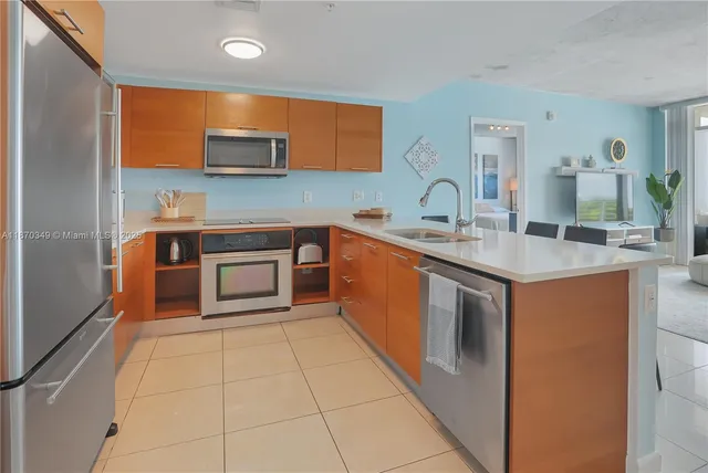 a kitchen with stainless steel appliances granite countertop a stove a sink and a microwave
