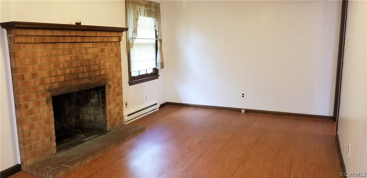 10830 Weybridge Road Chester, VA 23831 - Photo 13 of 33 an empty room with wooden floor and fireplace