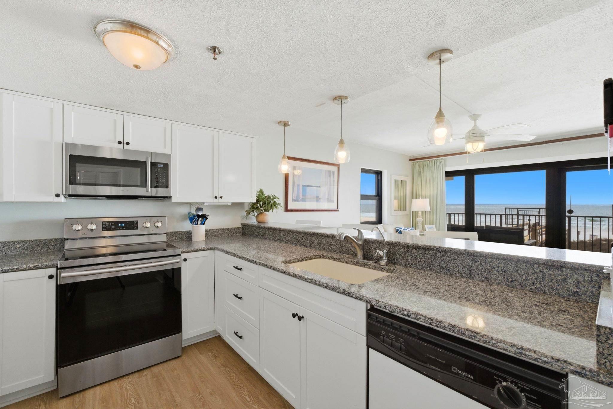 14623 Perdido Key Drive, Unit W201 Perdido Key, FL 32507 - Photo 12 of 57 a kitchen with stainless steel appliances granite countertop a stove sink and microwave