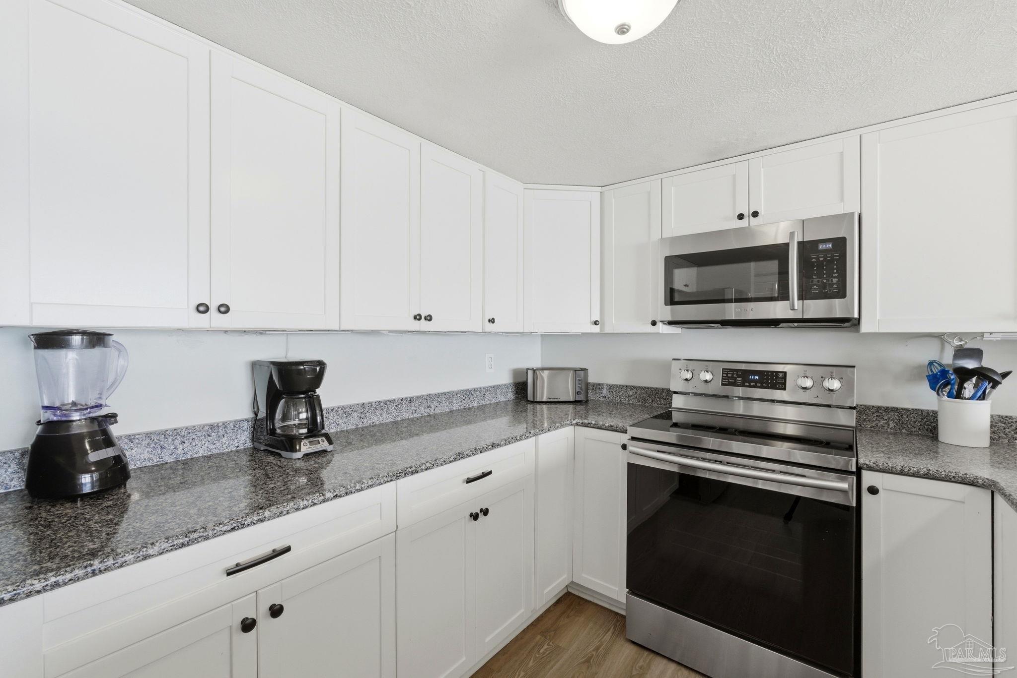 14623 Perdido Key Drive, Unit W201 Perdido Key, FL 32507 - Photo 13 of 57 a kitchen with granite countertop white cabinets and stainless steel appliances