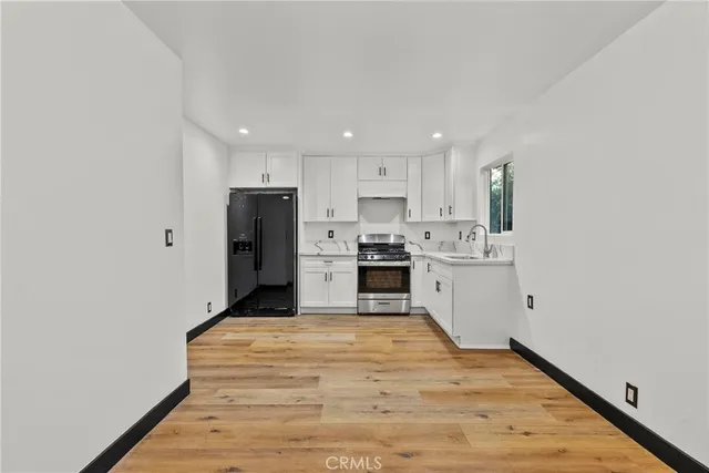 a kitchen with stainless steel appliances granite countertop a refrigerator sink and cabinets