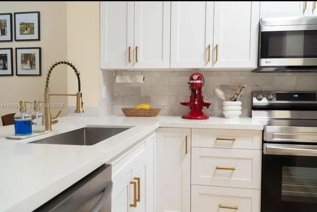 a kitchen with white cabinets and a sink