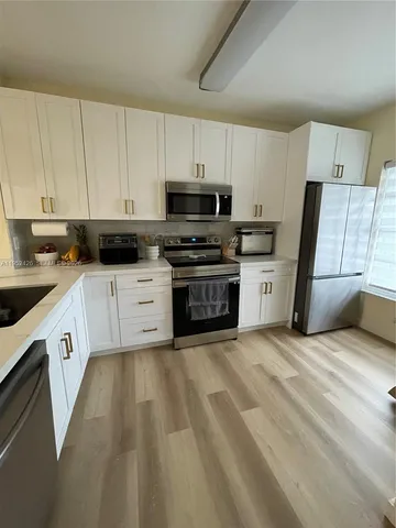 a kitchen with a sink a stove and cabinets