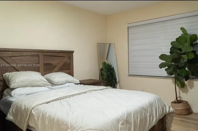a bedroom with a bed and a potted plant