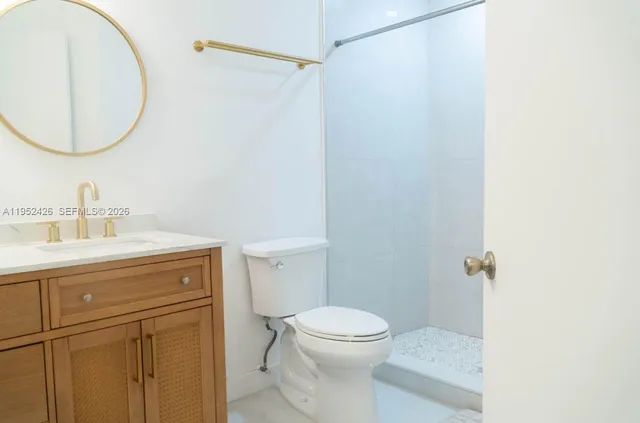 a bathroom with a granite countertop sink toilet and a mirror