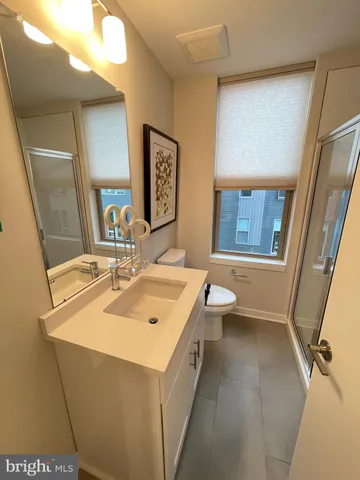 a bathroom with a sink a toilet and mirror
