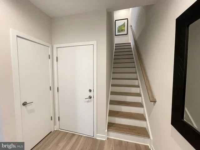a view of a hallway with wooden floor and entryway