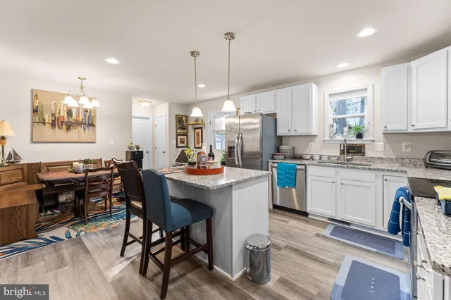 a kitchen that has a lot of cabinets a sink and appliances in it