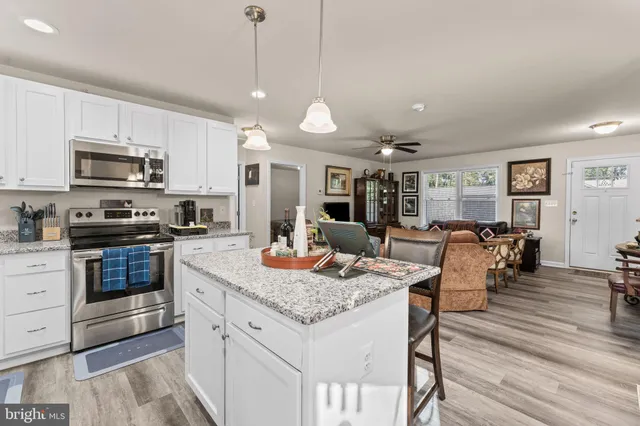 a kitchen with stainless steel appliances granite countertop a stove refrigerator and cabinets