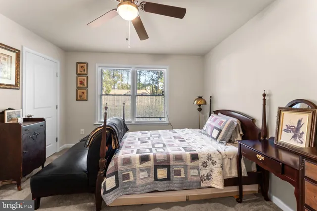 a bedroom with a bed a chair and a large window