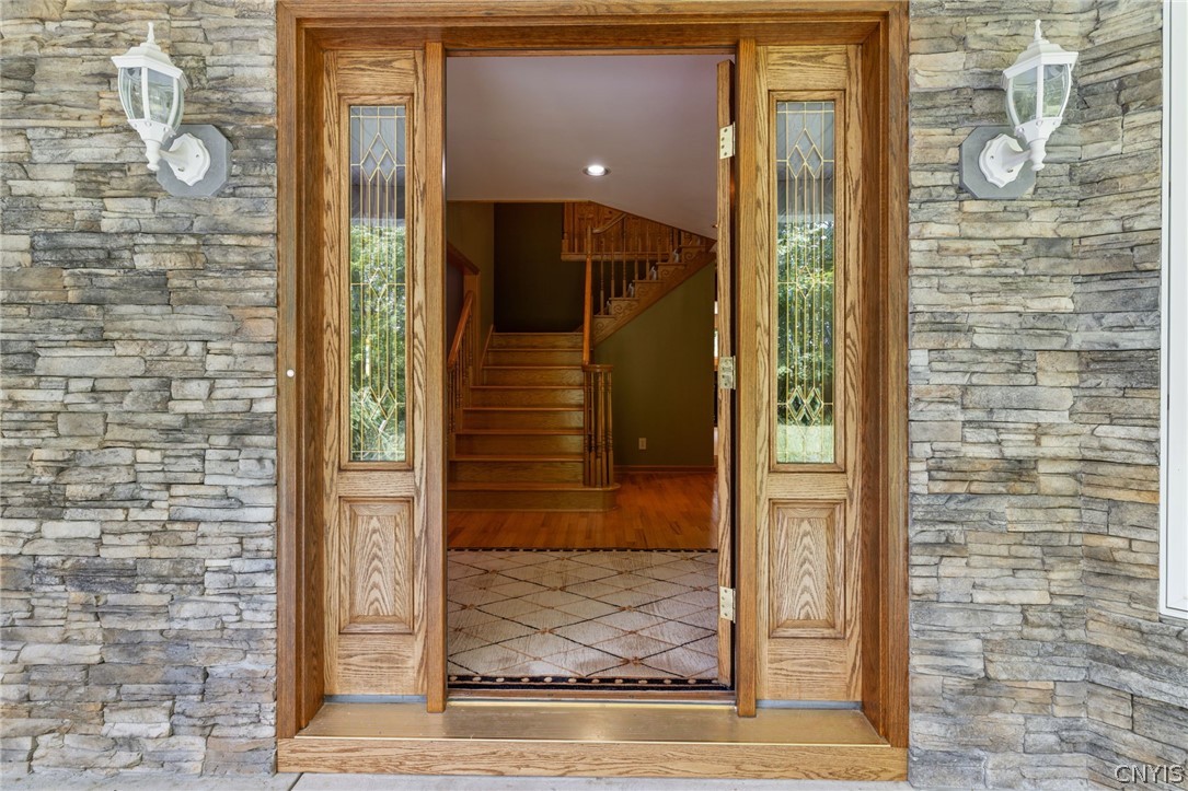 1103 Rail Fence Road Camillus, NY 13031 - Photo 7 of 50 The solid wood front door, complemented by beautiful stone accents, creates a striking first impression and reflects the custom craftsmanship found throughout the home. This is far from a cookie-cutter house—it's a thoughtfully designed home with character, quality, and timeless appeal.