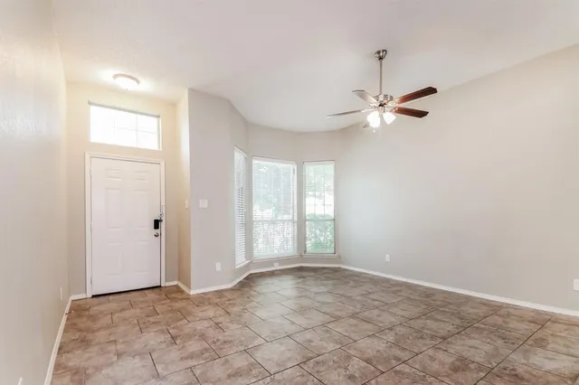an empty room with fan and windows