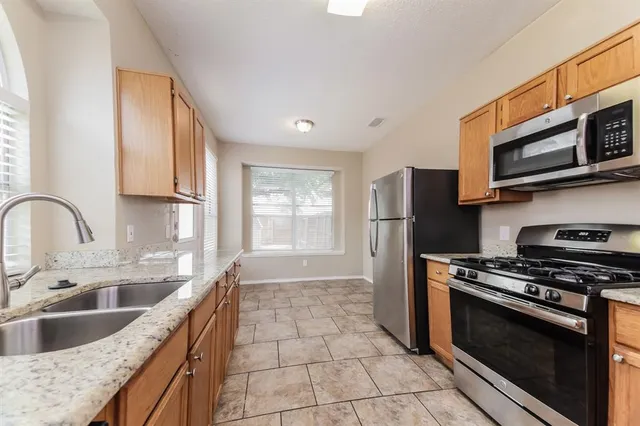 a kitchen with stainless steel appliances granite countertop a sink stove and microwave