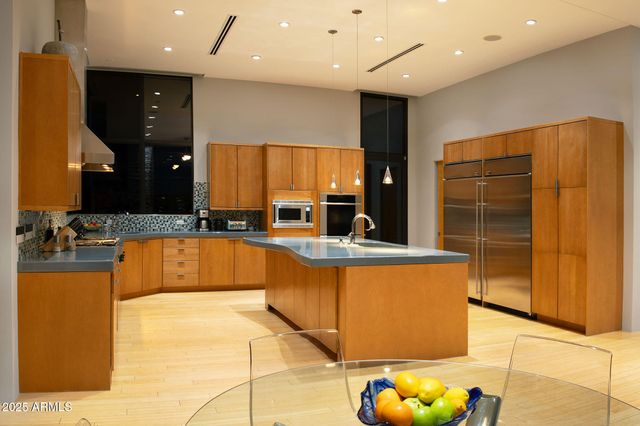a large kitchen with stainless steel appliances granite countertop a sink and a refrigerator
