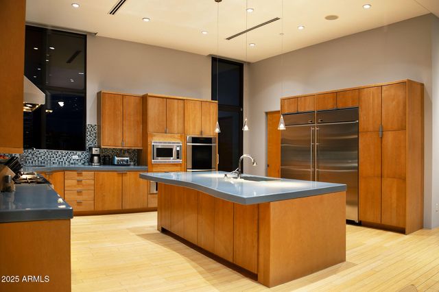 a kitchen with stainless steel appliances granite countertop a sink and a stove