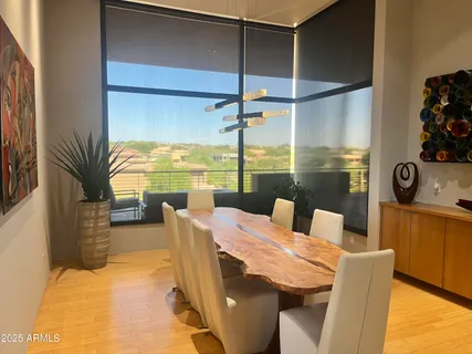 a dining room with furniture and a floor to ceiling window