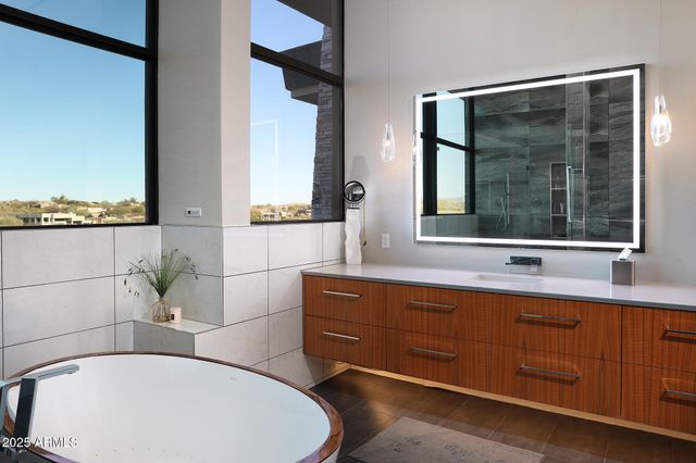 a bathroom with a tub sink and mirror