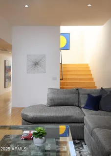 a living room with stainless steel appliances kitchen island granite countertop furniture and a wooden floor