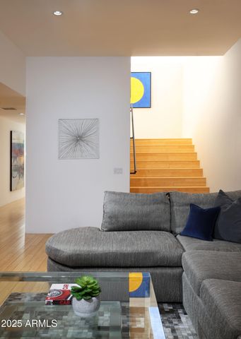 a living room with stainless steel appliances kitchen island granite countertop furniture and a wooden floor