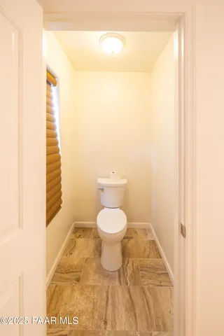 a bathroom with a granite countertop sink mirror vanity and toilet