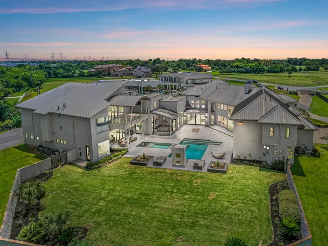 an aerial view of a house with garden space and a car parked in the yard