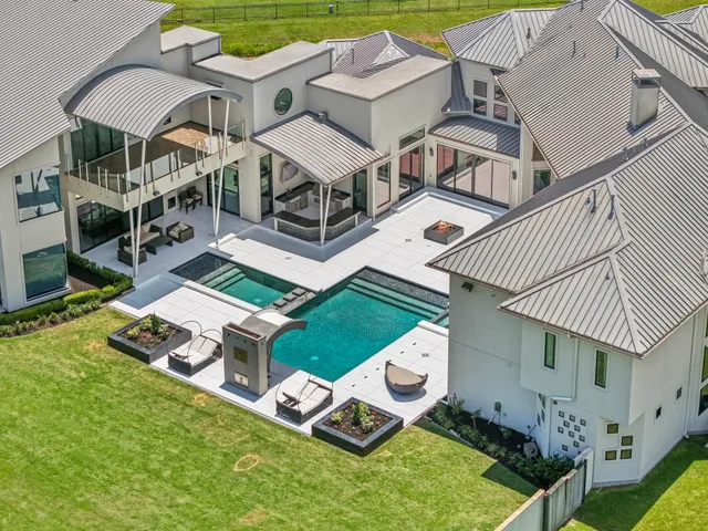 an aerial view of a house with swimming pool garden and patio