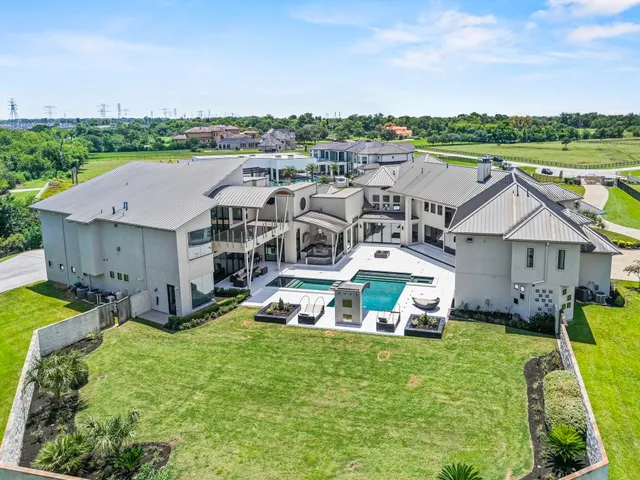 an aerial view of a house with a garden and lake view