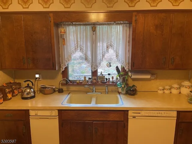 a view of a sink and dishwasher with wooden floor