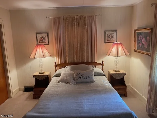 a bedroom with a bed and lamp on desk
