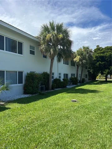 a view of a house with a yard and tree s