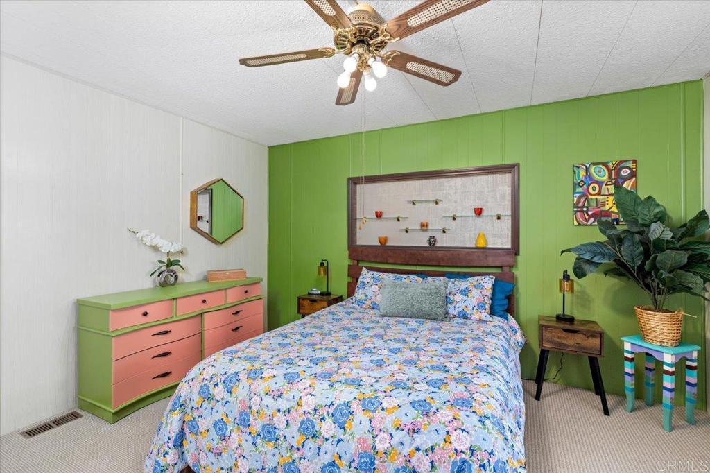 28890 Lilac Road, Unit 80 Valley Center, CA 92082 - Photo 14 of 33 a bedroom with a bed and paintings on the wall