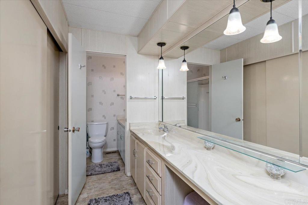 28890 Lilac Road, Unit 80 Valley Center, CA 92082 - Photo 17 of 33 a bathroom with a granite countertop sink a toilet and shower