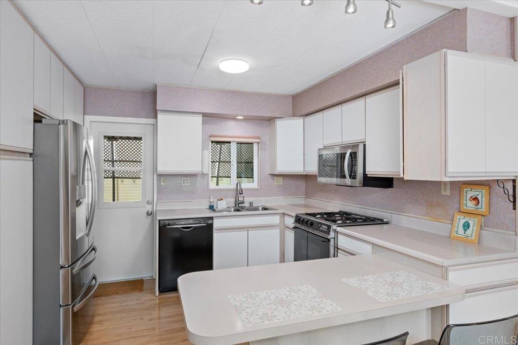 28890 Lilac Road, Unit 80 Valley Center, CA 92082 - Photo 8 of 33 a kitchen with stainless steel appliances a sink a stove a refrigerator cabinets and a window
