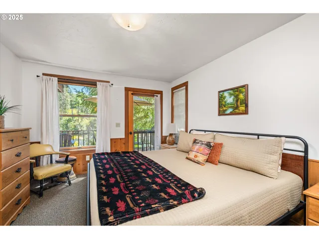 a bedroom with a bed a couch and large window