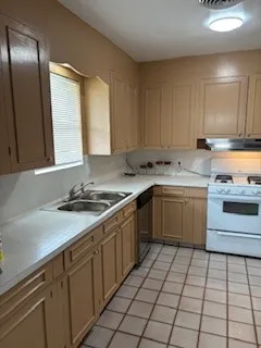 a kitchen with a sink stove and cabinets