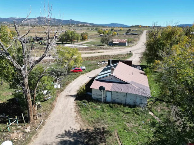 a view of a backyard with barn and large trees