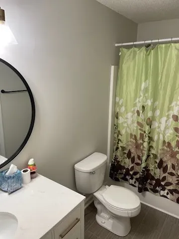 a white toilet sitting next to a bathroom sink and a shower