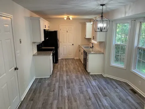 a kitchen with sink a refrigerator and wooden floor