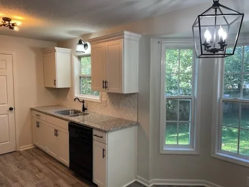 a kitchen with a granite countertop sink and a window