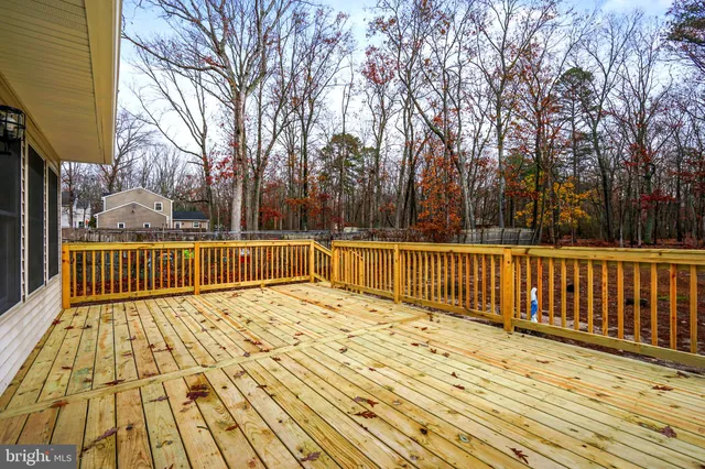 a view of deck with wooden fence and trees