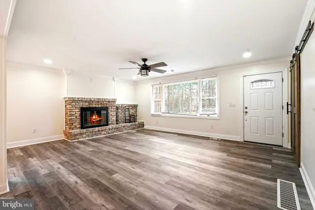 an empty room with windows and fireplace