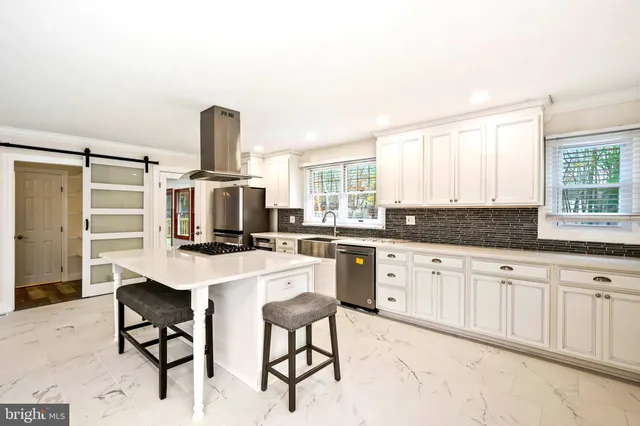 a kitchen with stainless steel appliances a stove top oven and a refrigerator