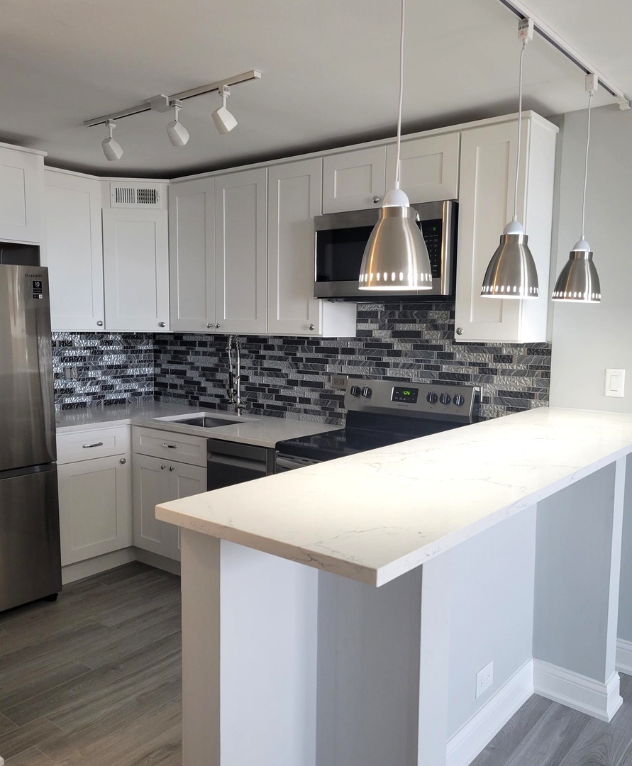 655 West Irving Park Road, Unit 2611 Chicago, IL 60613 - Photo 11 of 32 a kitchen with stainless steel appliances a stove a sink and a refrigerator