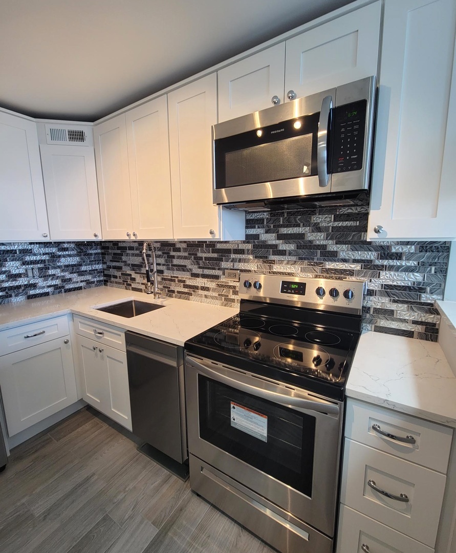 655 West Irving Park Road, Unit 2611 Chicago, IL 60613 - Photo 21 of 32 a kitchen with a stove and a microwave