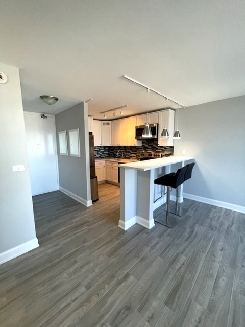655 West Irving Park Road, Unit 2611 Chicago, IL 60613 - Photo 7 of 32 a view of a workspace with furniture and wooden floor