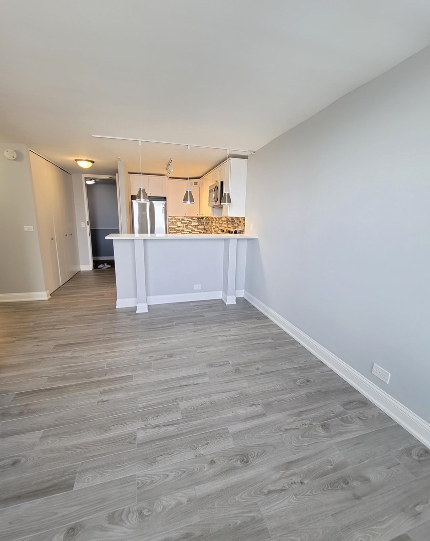 655 West Irving Park Road, Unit 2611 Chicago, IL 60613 - Photo 8 of 32 a view of a kitchen with furniture and wooden floor